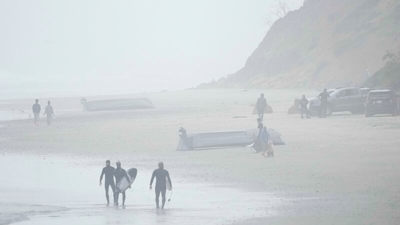 Two boats, one overturned, sit on Blacks Beach, Sunday, March 12, 2023, in San Diego....